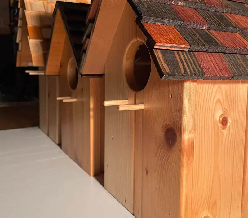 Close-up of handcrafted bird houses with individually cut roof shingles