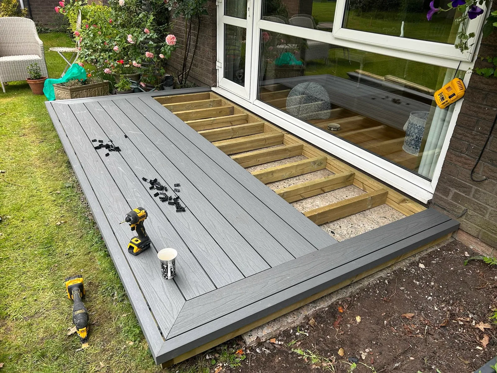 Composite decking mid-installation showing precise structural timber subframe