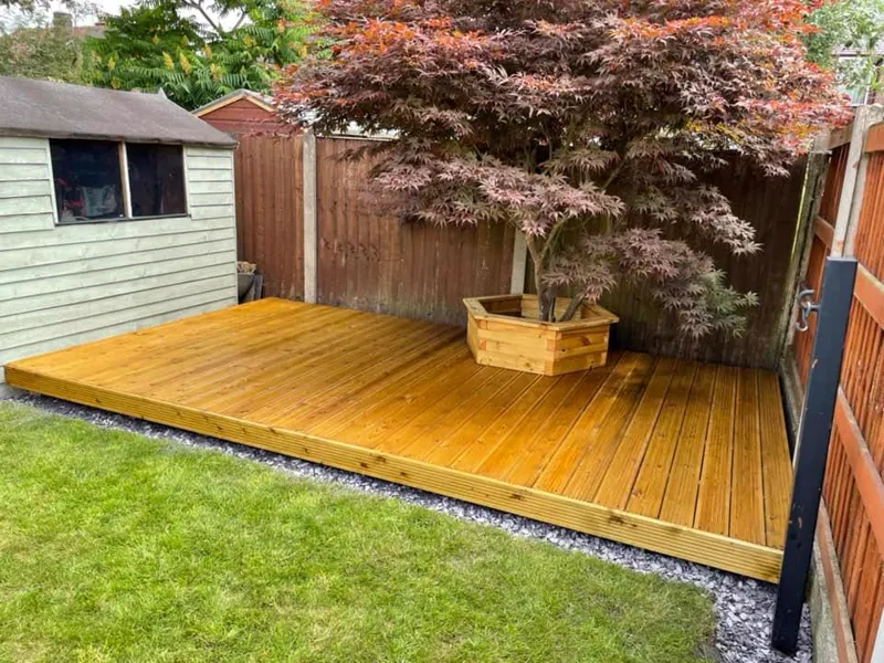 Golden timber decking built around a Japanese acer with hexagonal tree planter