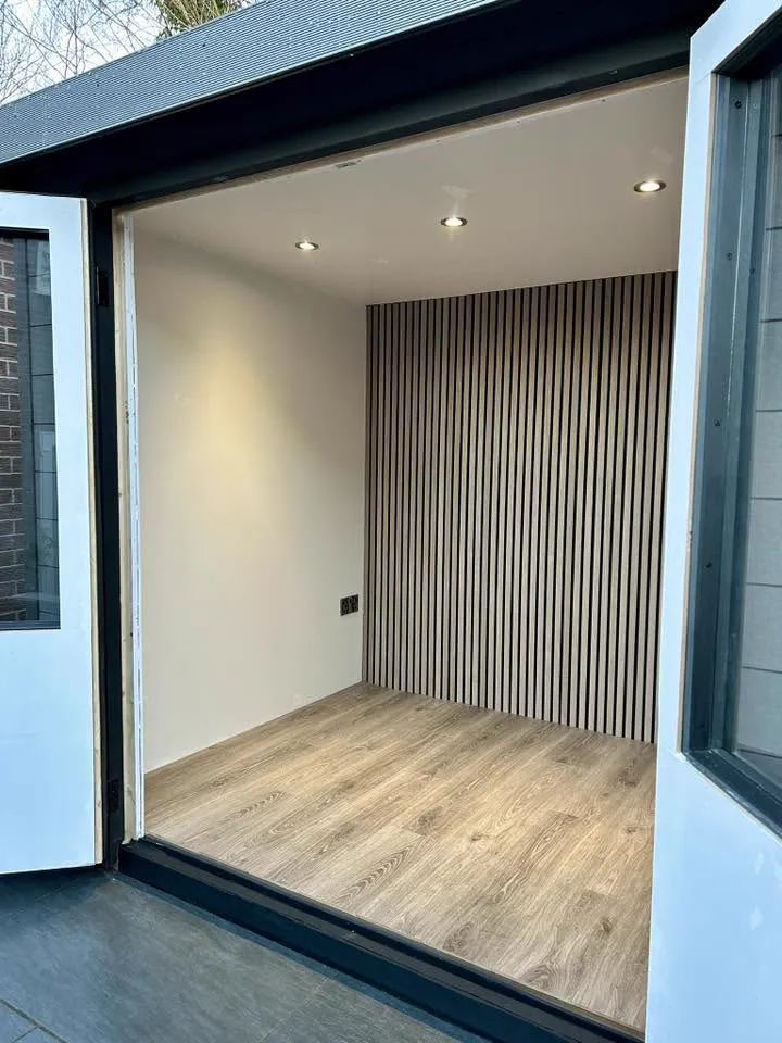 Garden room interior with oak floor and acoustic slat feature wall