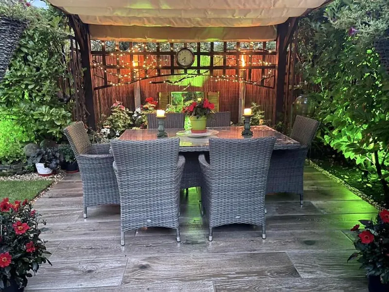 Gazebo dining space with fairy lights and wood-effect porcelain floor