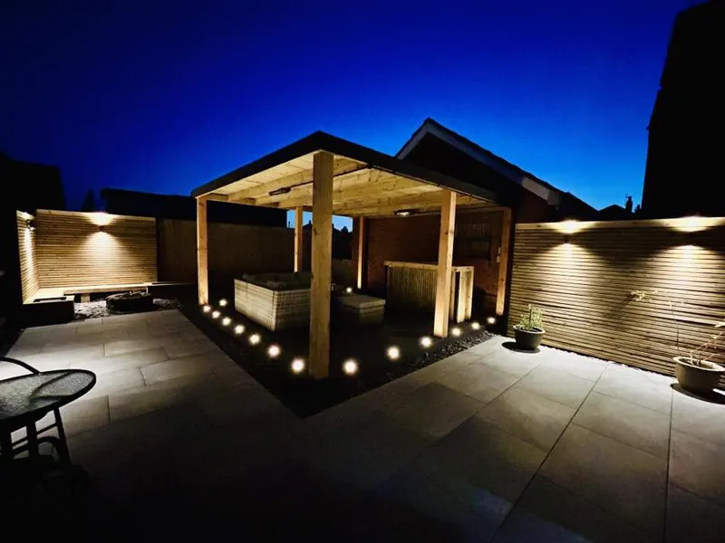 Timber gazebo glowing with recessed lights under deep blue night sky