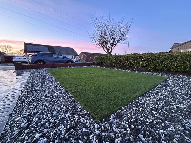 Front lawn with slate cobble border and paved driveway at sunset